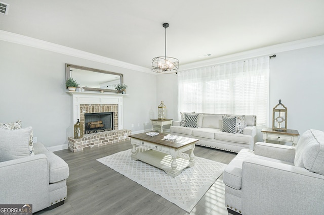 living area with wood finished floors, visible vents, baseboards, ornamental molding, and a brick fireplace