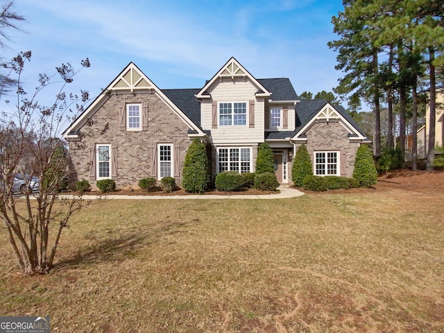 craftsman-style home featuring a front lawn and brick siding