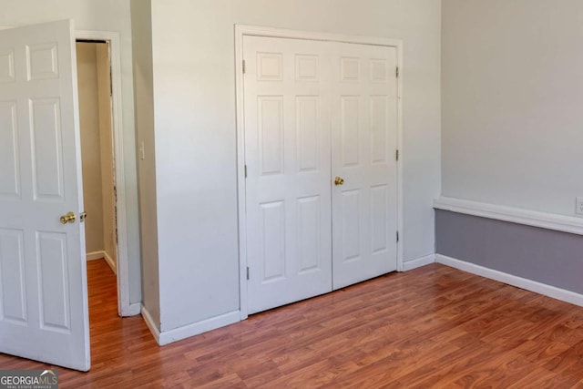 1004 Hamilton Dr, Locust Grove, GA 30248 - unfurnished bedroom featuring a closet, wood finished floors, and baseboards