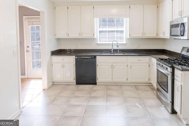 1004 Hamilton Dr, Locust Grove, GA 30248 - kitchen featuring stainless steel appliances, dark countertops, a sink, and white cabinets