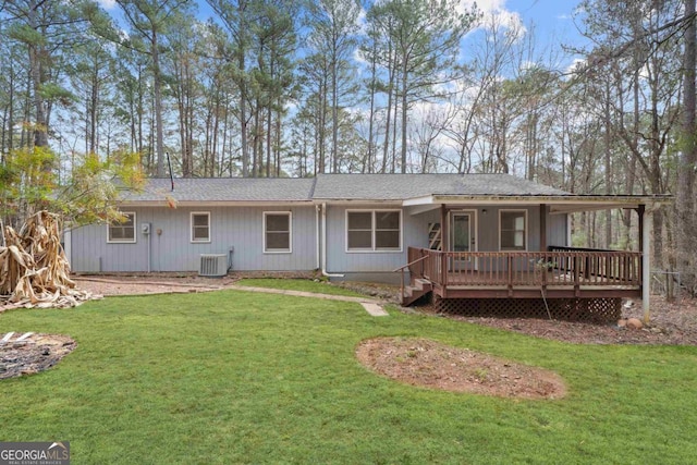 rear view of house featuring a deck, a yard, and central AC unit