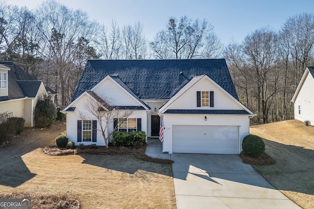 traditional-style home featuring a shingled roof, concrete driveway, and an attached garage