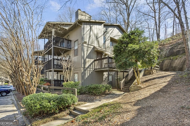 view of home's exterior featuring a chimney and stairway