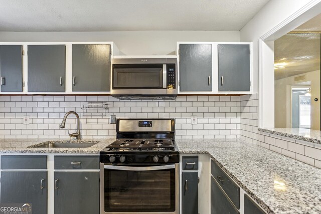 2701 Cumberland Ct SE, Smyrna, GA 30080 - kitchen featuring backsplash, appliances with stainless steel finishes, light stone counters, and a sink