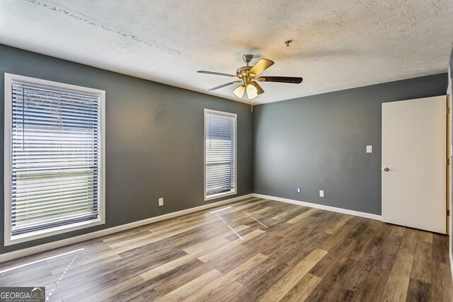 2701 Cumberland Ct SE, Smyrna, GA 30080 - spare room featuring a ceiling fan, a textured ceiling, baseboards, and wood finished floors