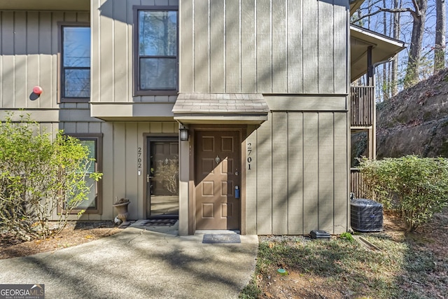 entrance to property with board and batten siding and central AC unit