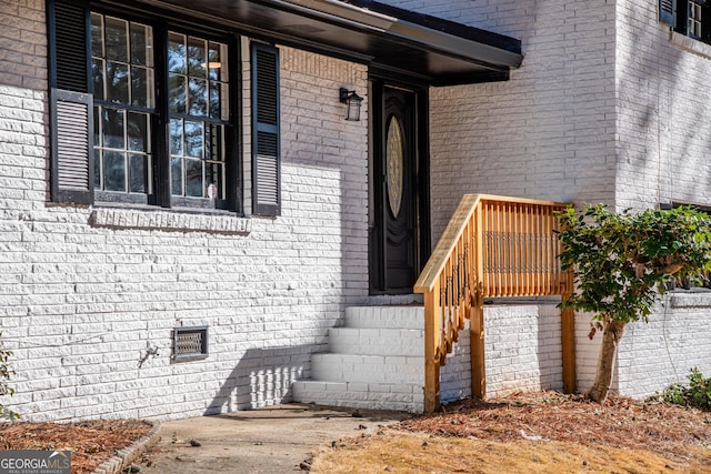 entrance to property featuring brick siding and crawl space