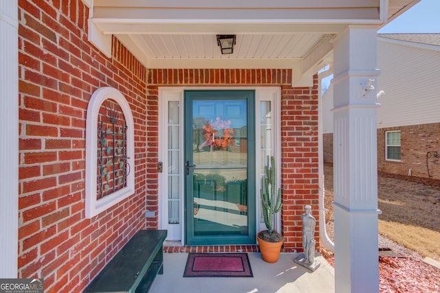 view of exterior entry featuring brick siding