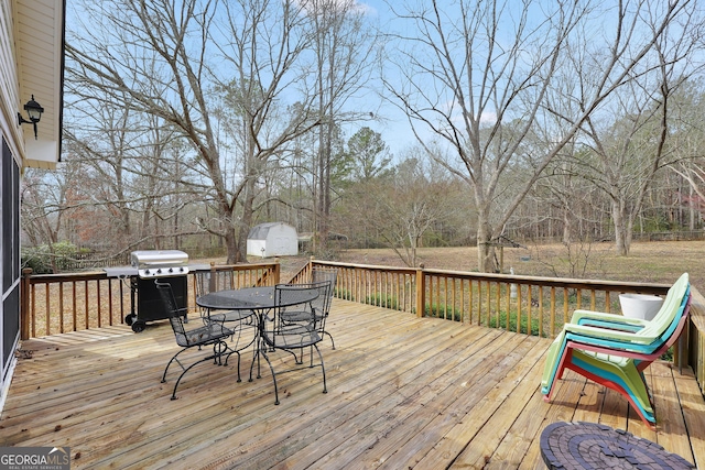 wooden terrace with area for grilling and outdoor dining space