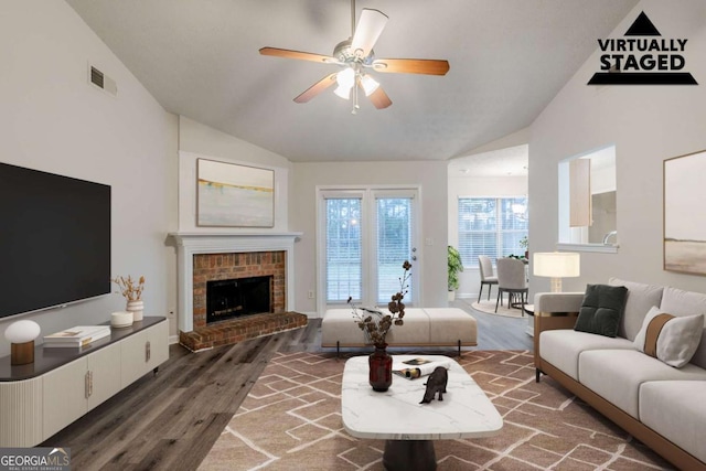 living room featuring visible vents, a ceiling fan, wood finished floors, a fireplace, and high vaulted ceiling