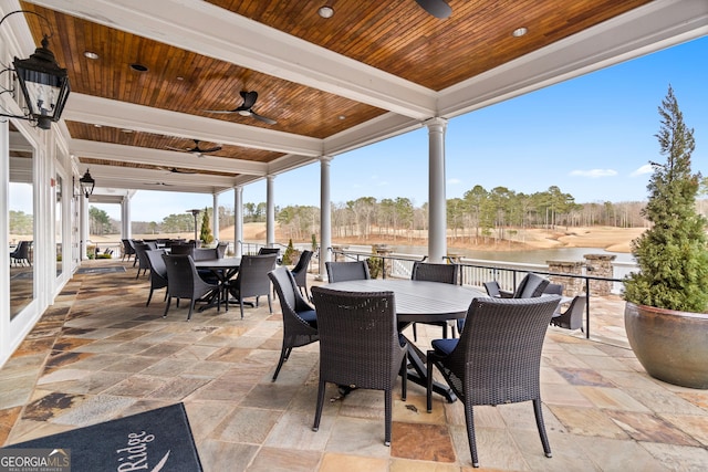 view of patio / terrace featuring outdoor dining area, a water view, and a ceiling fan