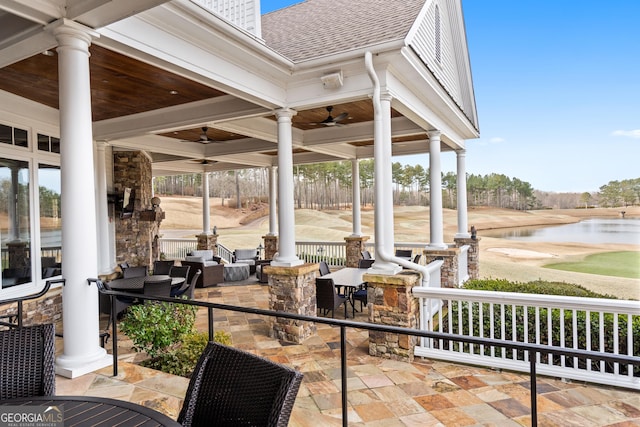 view of patio featuring outdoor dining area, a water view, and a ceiling fan