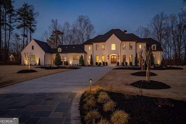 mediterranean / spanish-style home with curved driveway and stucco siding