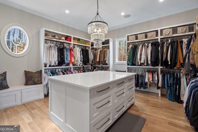 walk in closet featuring light wood-style floors and a notable chandelier