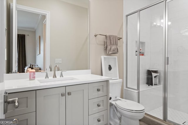 bathroom featuring toilet, vanity, and a shower stall