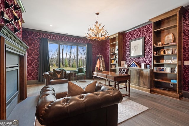 home office featuring wallpapered walls, a notable chandelier, baseboards, and wood finished floors