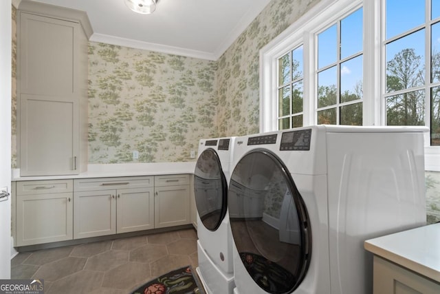 washroom featuring ornamental molding, washing machine and clothes dryer, cabinet space, and wallpapered walls