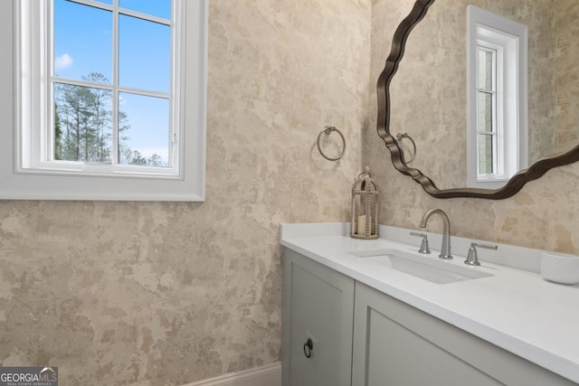 bathroom with vanity and wallpapered walls