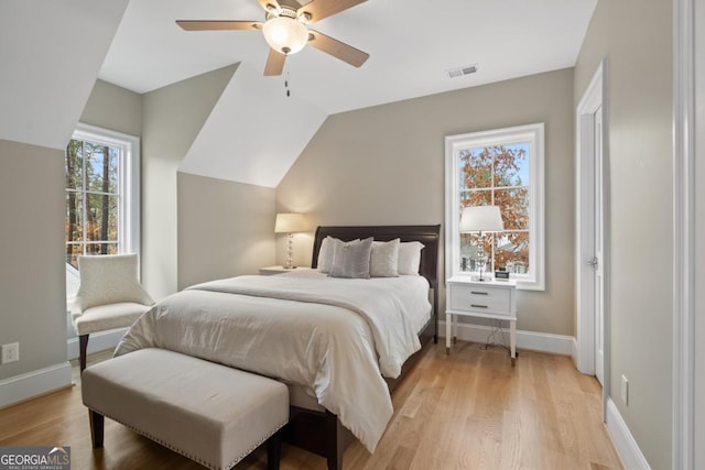 bedroom with lofted ceiling, ceiling fan, visible vents, baseboards, and light wood finished floors