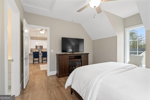 bedroom with light wood-type flooring, ceiling fan, baseboards, and vaulted ceiling