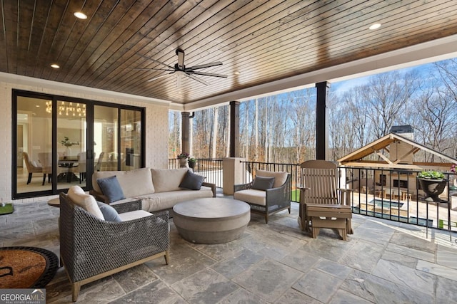 sunroom featuring wood ceiling and ceiling fan