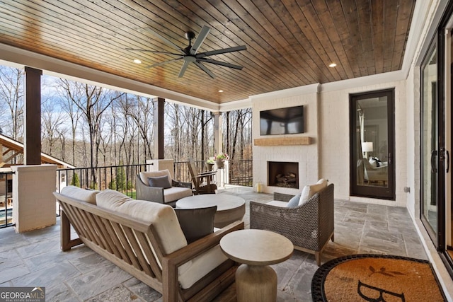 view of patio featuring a ceiling fan and an outdoor living space with a fireplace