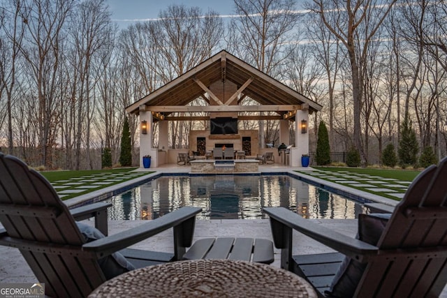 view of pool featuring an outdoor stone fireplace and a patio