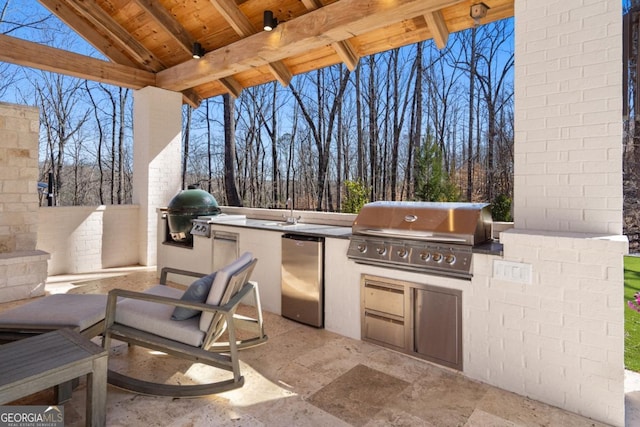 view of patio with exterior kitchen, area for grilling, and fence