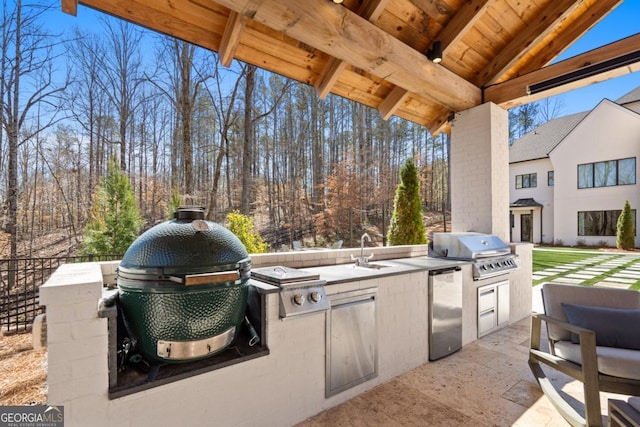 view of patio / terrace with a sink, exterior kitchen, and a grill