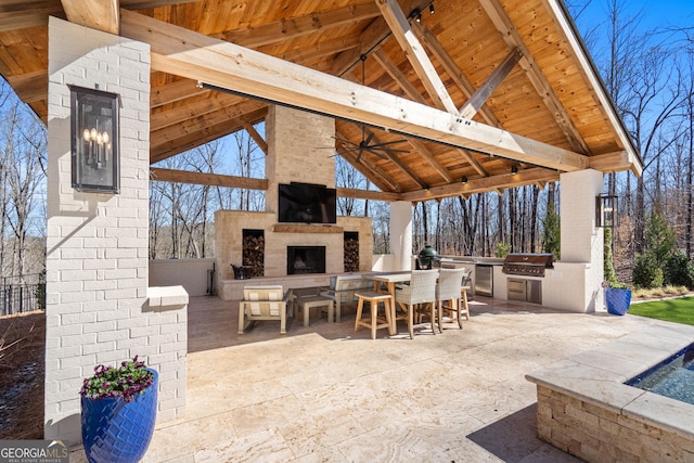 view of patio / terrace with exterior kitchen, a large fireplace, grilling area, and a gazebo