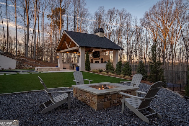 view of patio / terrace with fence, a fire pit, and a gazebo