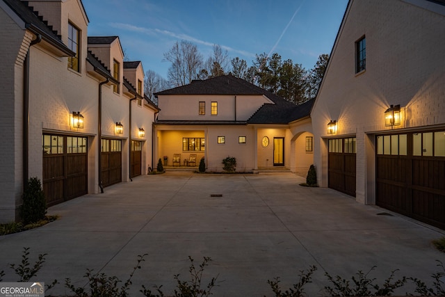 back of property at dusk with driveway