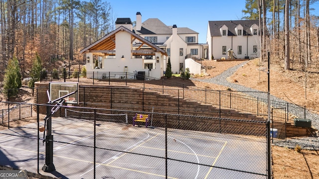 view of basketball court featuring basketball hoop and fence