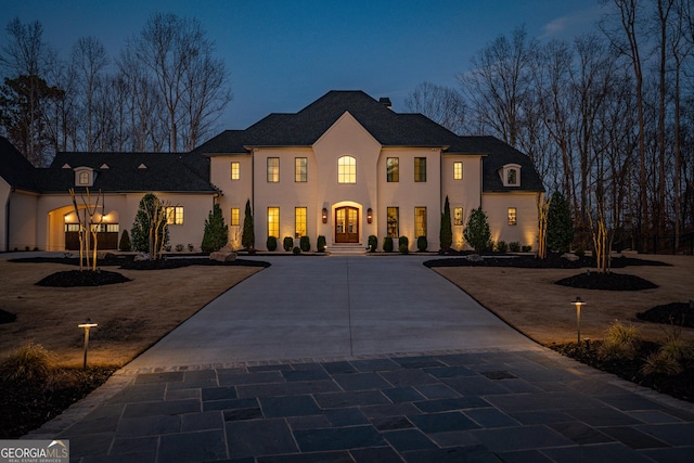 view of front of home with curved driveway and stucco siding