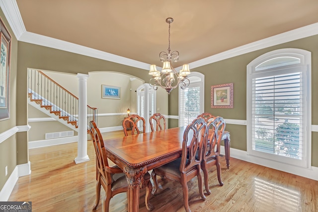 dining area featuring visible vents, arched walkways, ornamental molding, ornate columns, and light wood-style floors