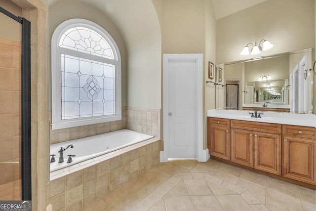 full bath with vanity, a bath, and tile patterned floors