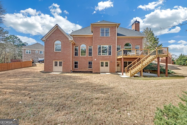 rear view of property with stairs, brick siding, a chimney, and a wooden deck