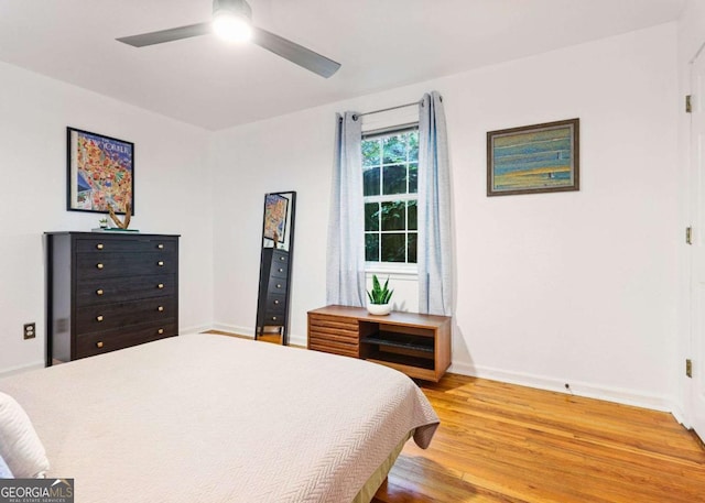 bedroom with a ceiling fan, baseboards, and wood finished floors