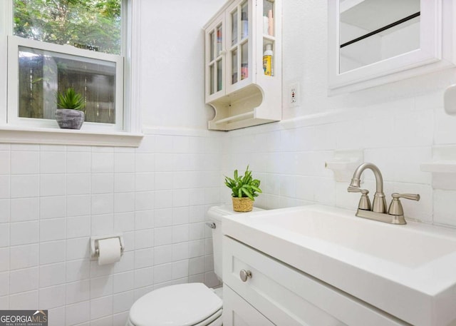 bathroom featuring tile walls, a wainscoted wall, vanity, and toilet