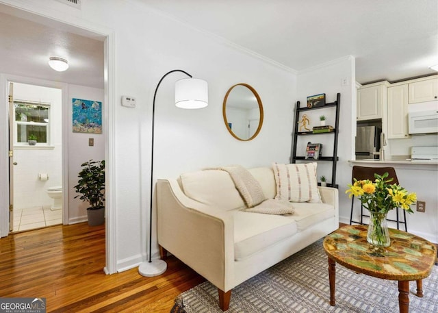 living room with baseboards, ornamental molding, and dark wood-style flooring