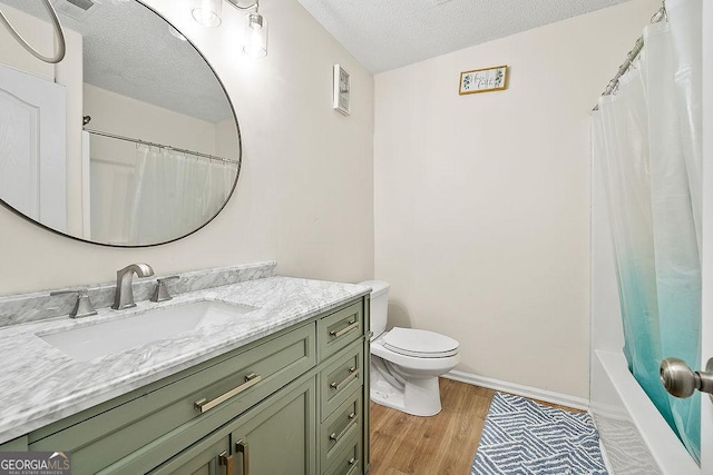 full bathroom featuring baseboards, toilet, wood finished floors, a textured ceiling, and vanity