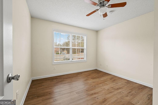 unfurnished room featuring a textured ceiling, ceiling fan, baseboards, and light wood-style floors