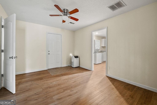 spare room featuring light wood-style flooring, visible vents, and baseboards