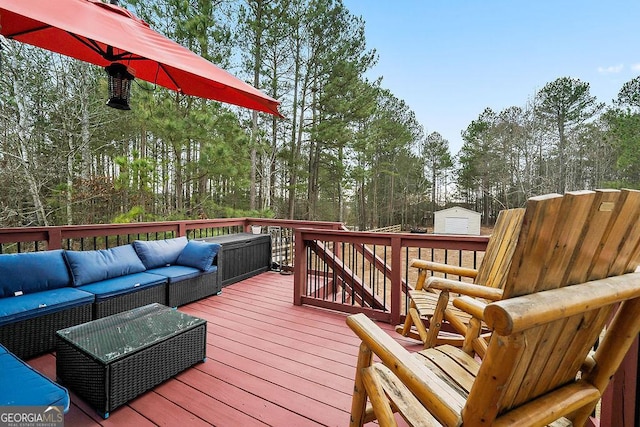 wooden terrace featuring outdoor lounge area, an outdoor structure, and a storage shed