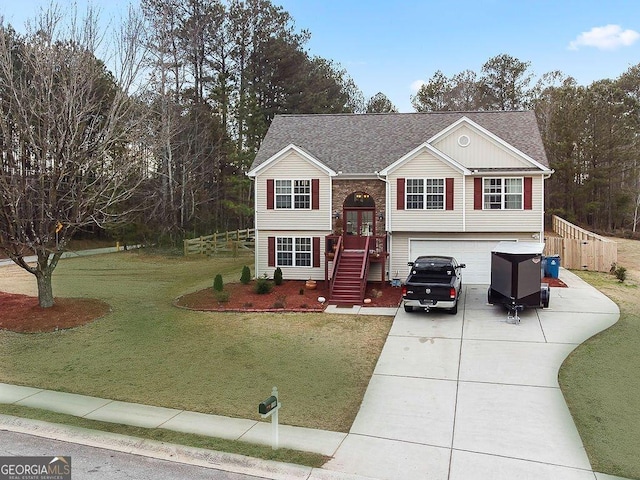 split foyer home featuring an attached garage, a shingled roof, stairs, driveway, and a front yard