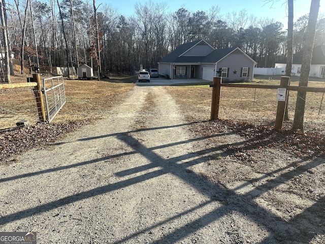 view of street featuring driveway, a gated entry, and a gate