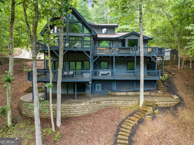 back of house featuring stairway and a deck