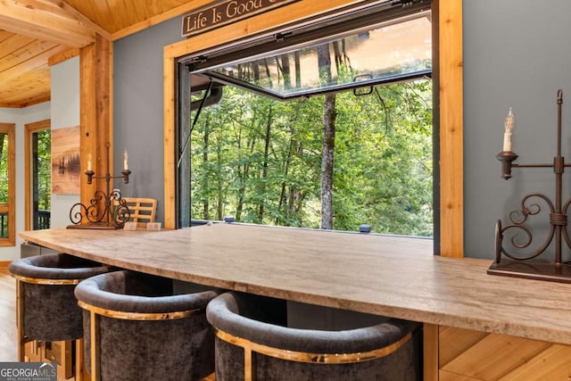 dining area with wooden ceiling and wood finished floors