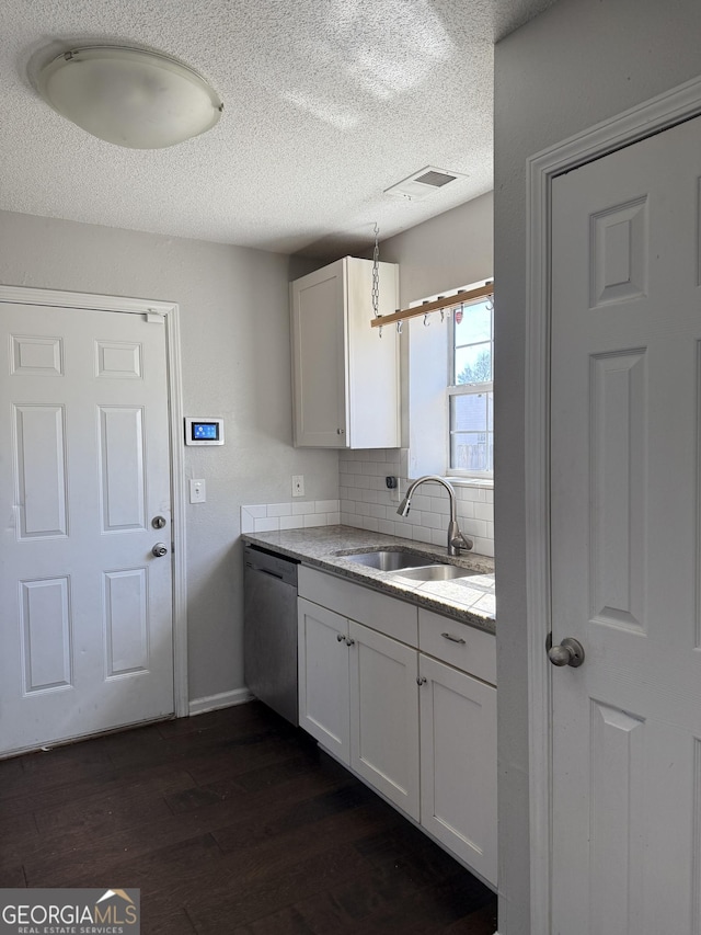 kitchen featuring dark wood finished floors, white cabinets, a sink, and stainless steel dishwasher