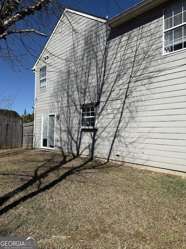 rear view of property with a yard and fence